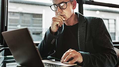 a person intently researching on laptop