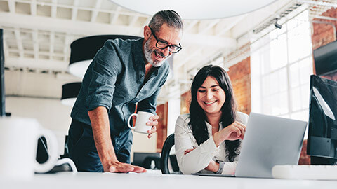 2 colleagues discussing a work project in a modern office space