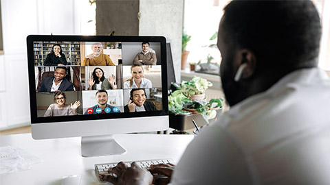 Successful african american young man talking on video conference with colleagues of different nationalities, discussing the project and strategy.