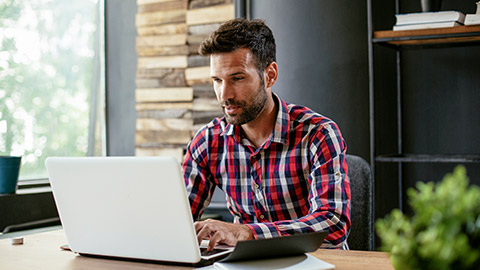 Young businessman working on laptop at office. Businessman sitting at office desk working on new project