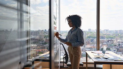 Young African american executive manager businesswoman writing strategy ideas on sticky notes