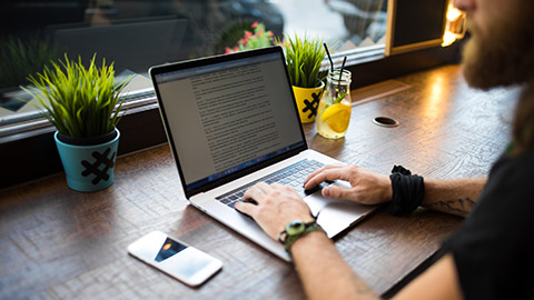 A hipster typing on a laptop