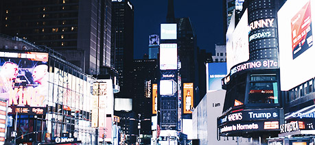 An image of a street at night being lit up by ads on buildings