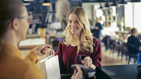 young woman paying at the counter