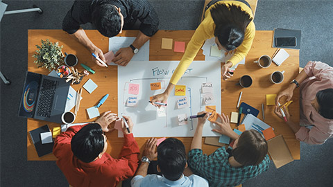 Top down aerial view of professional business people hands making scrum task board to manage workflow in workplace.