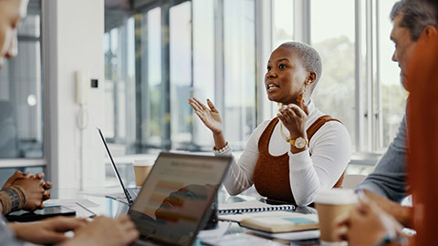 Meeting, discussion and professional black woman talking to her colleagues in the office conference room.