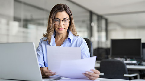 Busy mature business woman entrepreneur working in office checking legal document account invoice in office