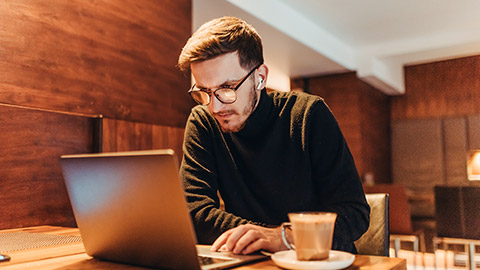 Happy young businessman working on a laptop