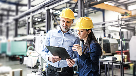 Two project managers standing in modern industrial factory