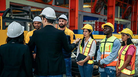 Team engineers and foreman stack hand and shake hands to show success at factory machines.