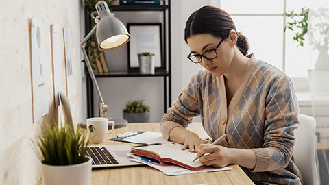 Happy casual beautiful woman working on a laptop at home.