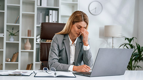 Tired, having headache. Woman in business formal clothes is working in office.