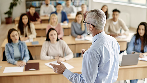 professor giving lecture to large group of college students