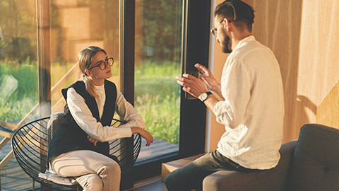 Serious businessman in glasses conducts an interview and talks about the company to a future employee