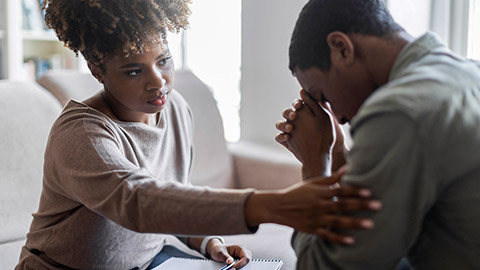 woman therapist consoling upset man