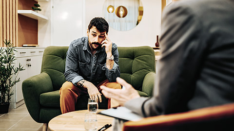 Worried client sitting with psychologist