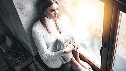 Woman sitting at windowsill