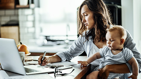 Mother with baby taking notes