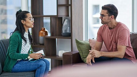 psychology or counseling with a woman therapist and male patient talking in her office