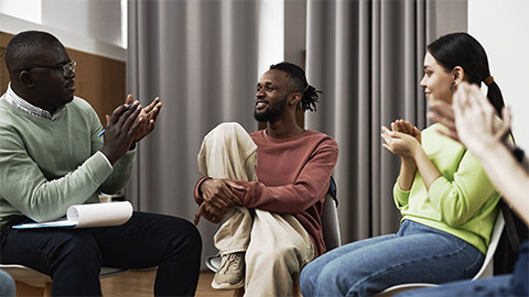 A black counselor talking to young patients