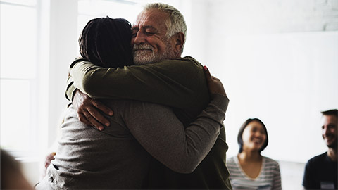 An elderly man hugging his counsilor