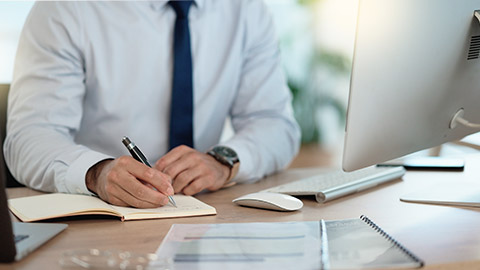 attorney working on corporate plans and compiling legal reports for a case at his desk.