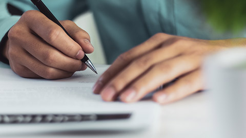 man signing a document after reading the agreement in office