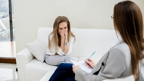 A young woman during depression communicates with a psychologist in the office