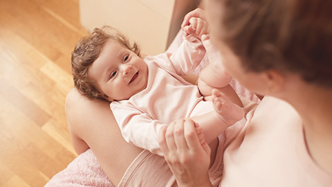 baby girl under 1 year old lying on mother hands in room