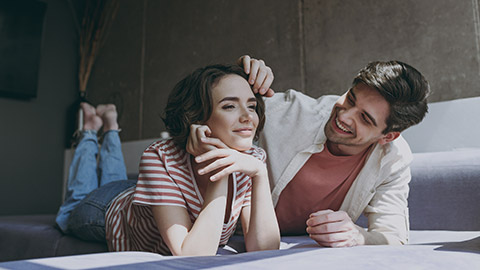 young couple in casual clothes lying on sofa