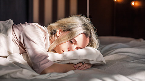 Tired middle aged woman lying in bed can't sleep late at morning with insomnia