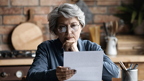 matured woman reading letter carefully