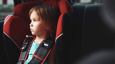 A close view of a child in their seat in a car