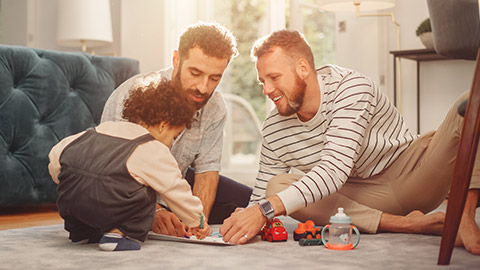 A same-sex couple playing with their child