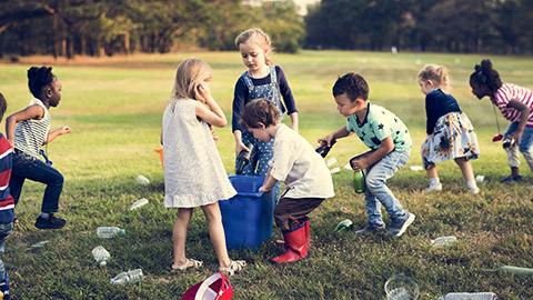 A group of kids collecting rubbish in an outdoor area