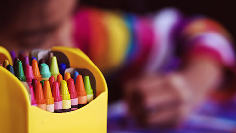 A close view of a child using crayons