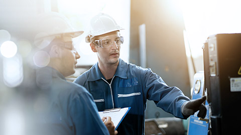 Two engineers inspecting quality of a machine