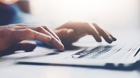 A close view of a person typing on a laptop