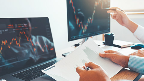 A close view of traders watching stock prices on computer screens