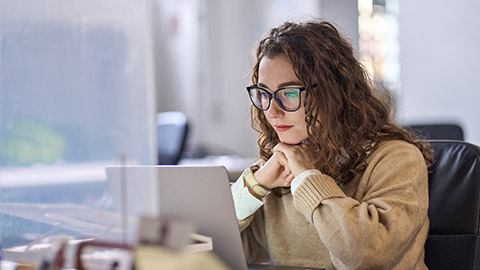 Young serious busy professional business woman employee working on a computer