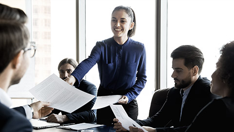 A person handing out presentation materials