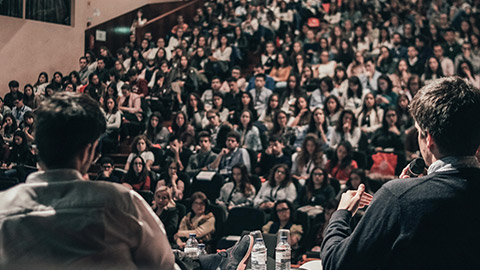 A wide view of a conference with a large crowd