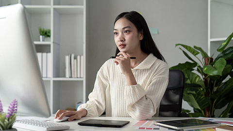 Asian woman graphic designer working in home office.