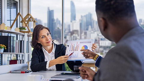 manager is showing annual report chart to her colleagues in the executive meeting