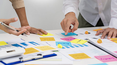 people brainstorming use sticky notes to share idea on table