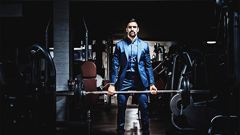 A gym manager doing deadlifts in a suit