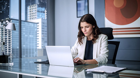 business woman sitting at desk working with computer