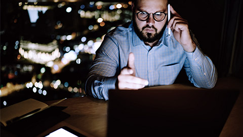 Serious businessman talking at the phone late at night