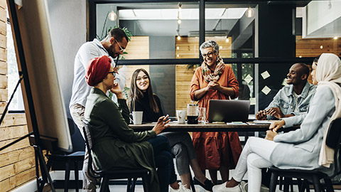 A diverse group of employees happily having a meeting