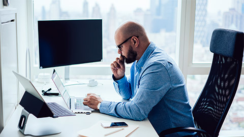 An employee sitting at their desk, deep in thought